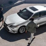 overhead image of two people approaching a silver Lexus ES