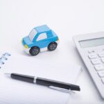 financing image with a calculator, notepad, and toy car