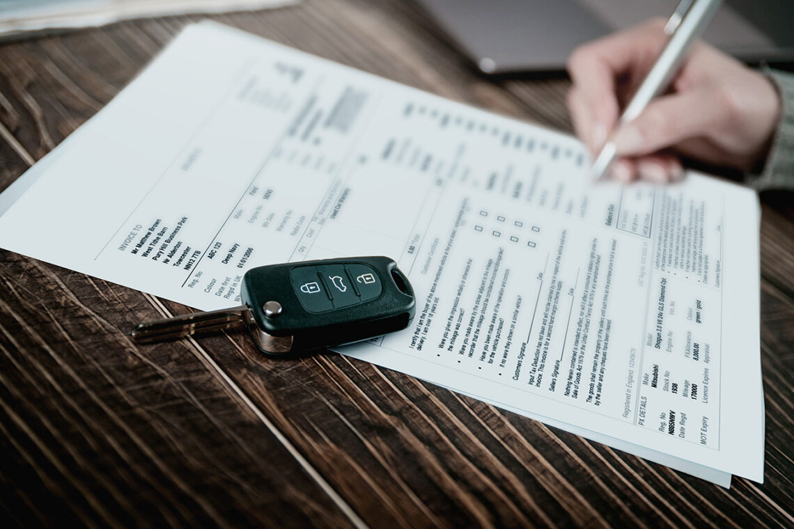 Filling out loan paperwork, a car key on the table