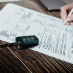 Filling out loan paperwork, a car key on the table