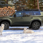 2026 Lexus GX parked in snow with two white dogs